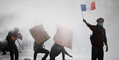Manifestante mascarado segura bandeira francesa durante protestos de estudantes e confrontos com for&ccedil;as de ordem, em Paris, em 13 de outubro de 2026. Foto: REUTERS - Sarah Meyssonnier / RFI